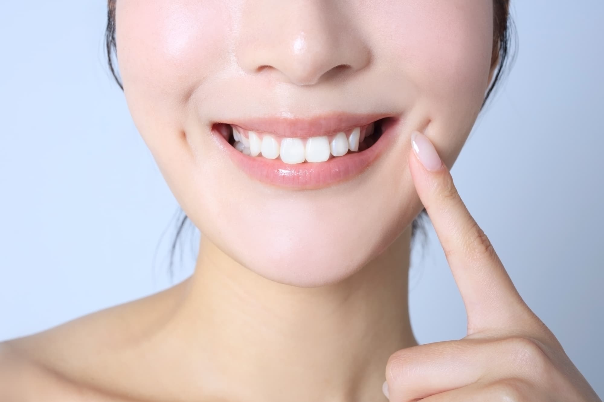 被せ物で治療した歯を指さす女性