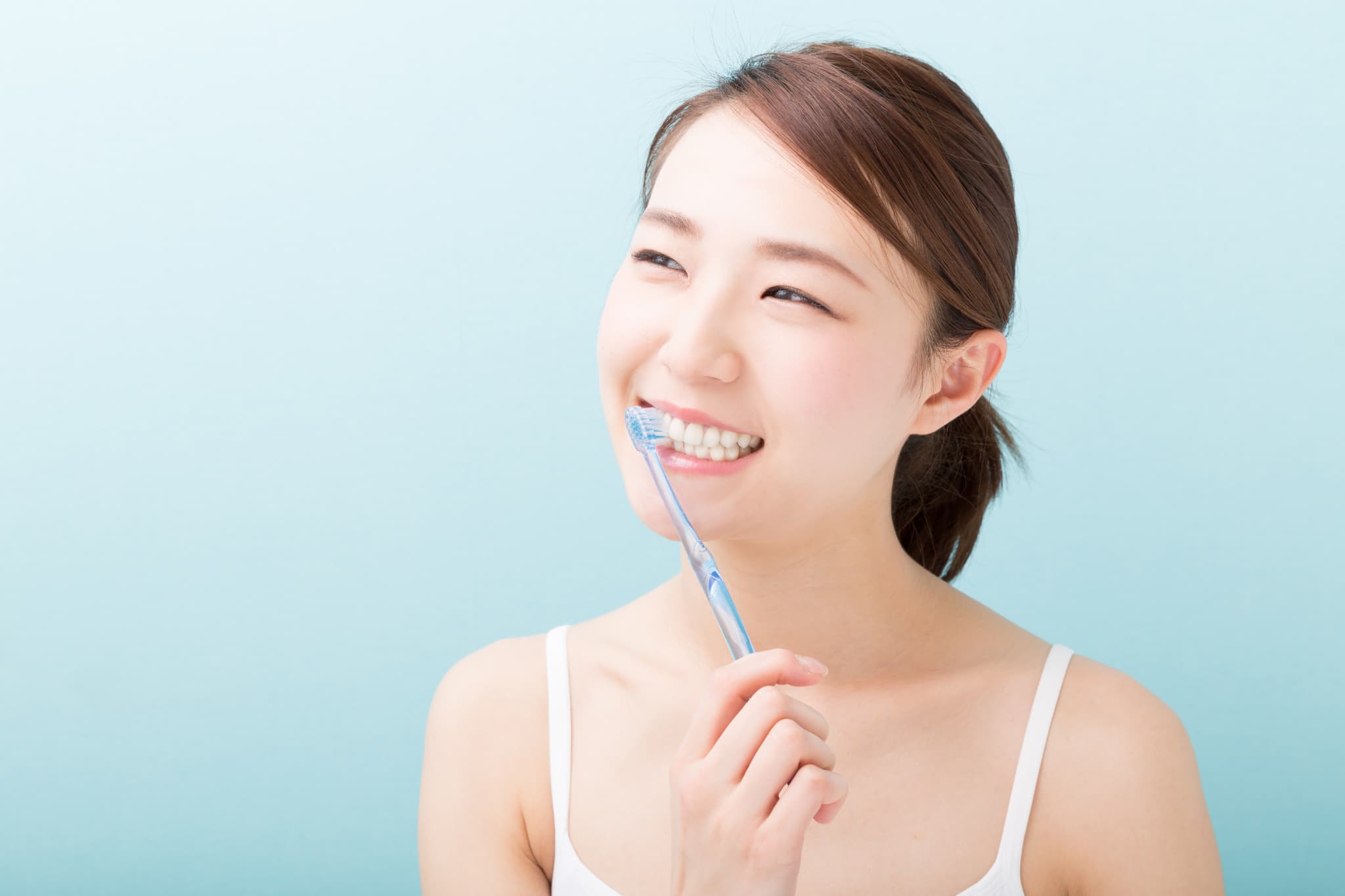 セラミック治療後の痛みを予防するためにしっかり歯磨きする女性