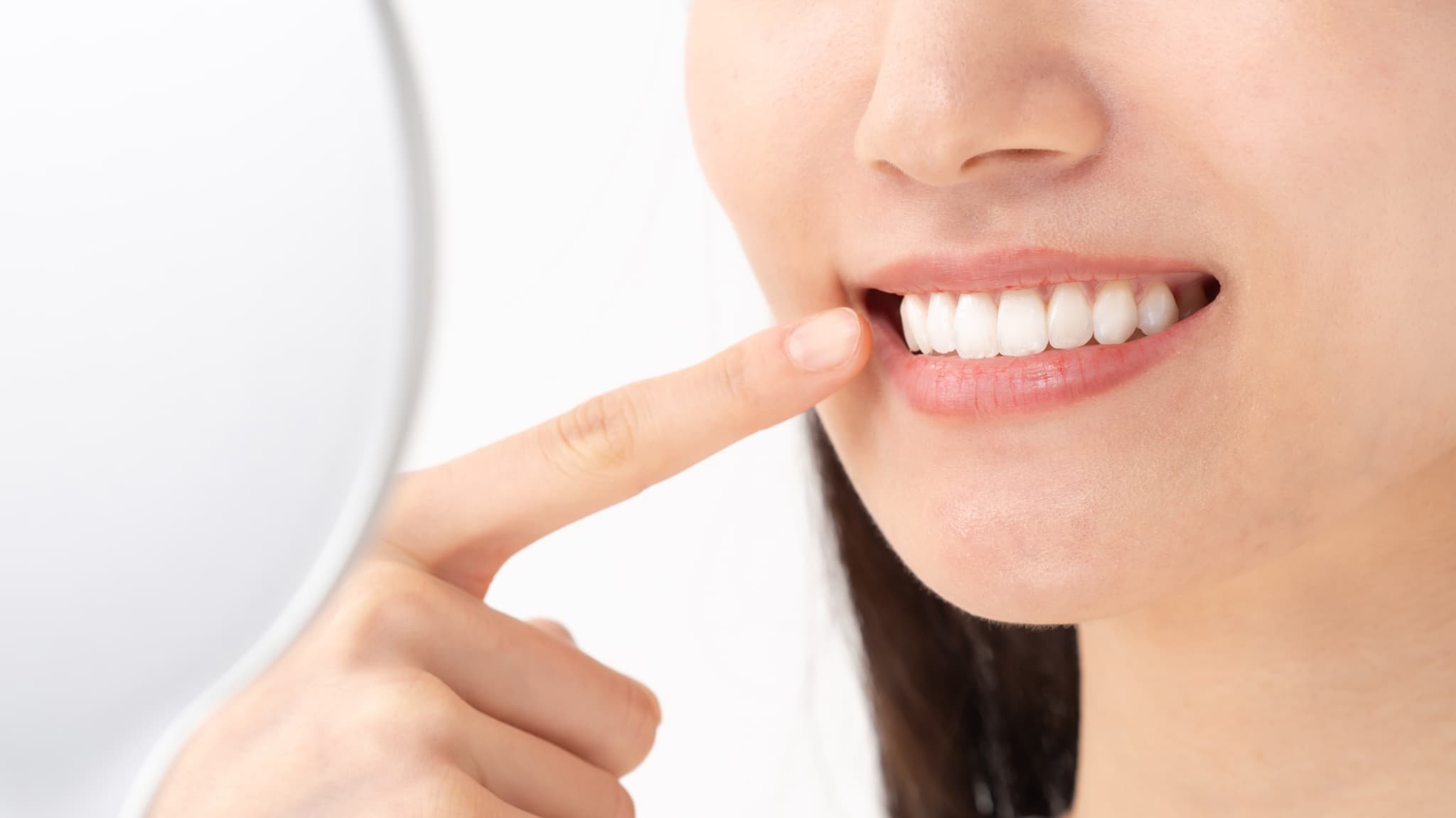 きれいな歯を指さす女性