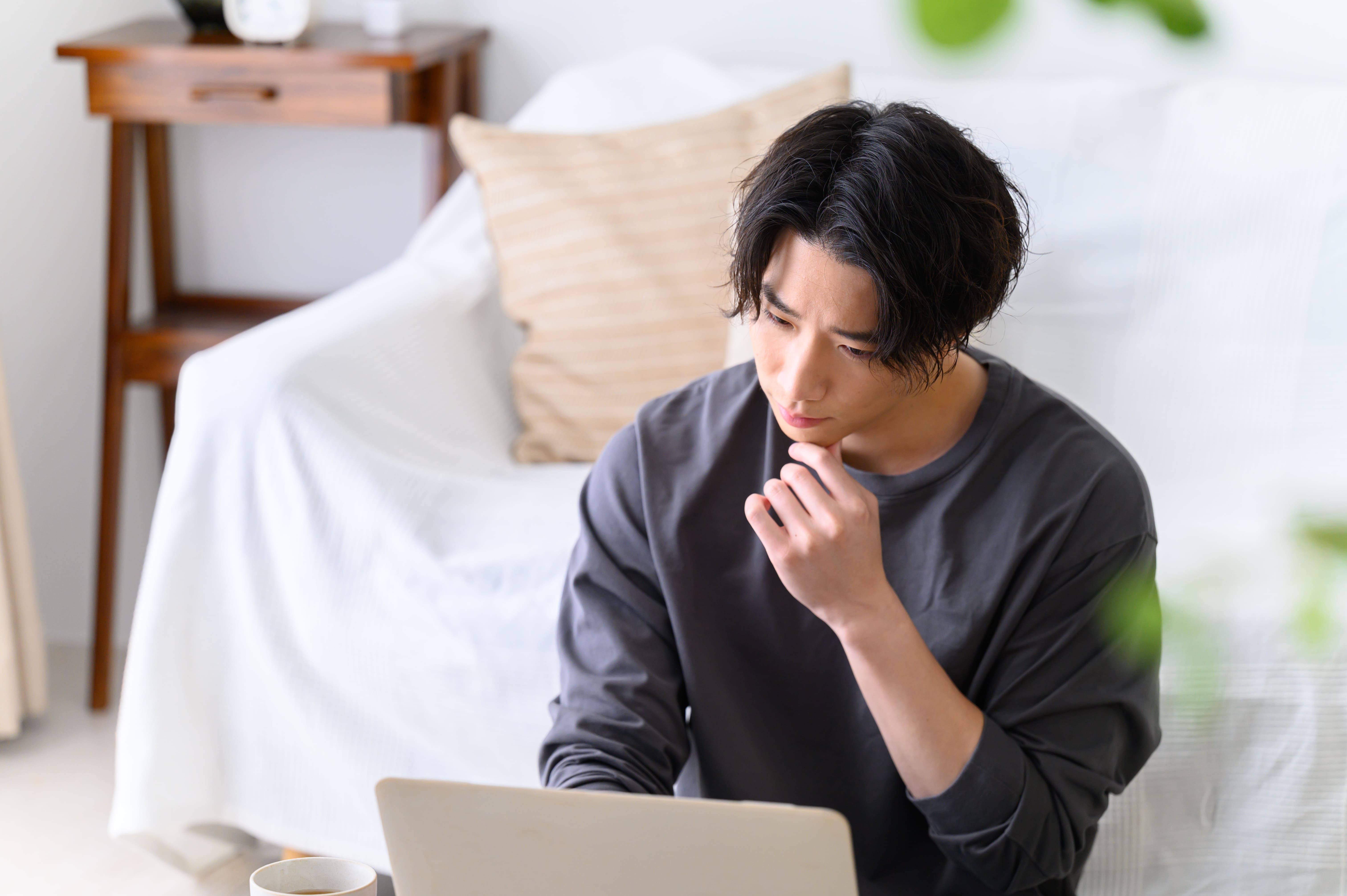 奥歯のインプラント治療が難しいといわれる理由を考えている男性