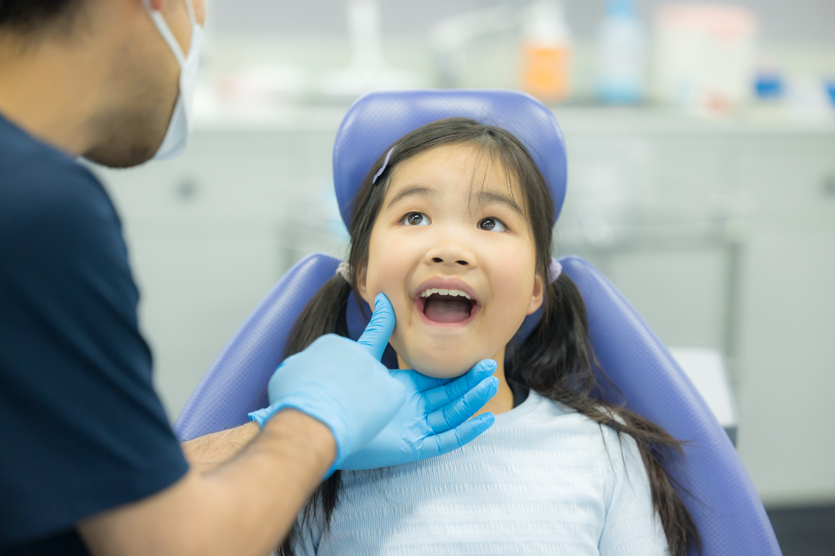 子どもの歯をチェックする歯科医師