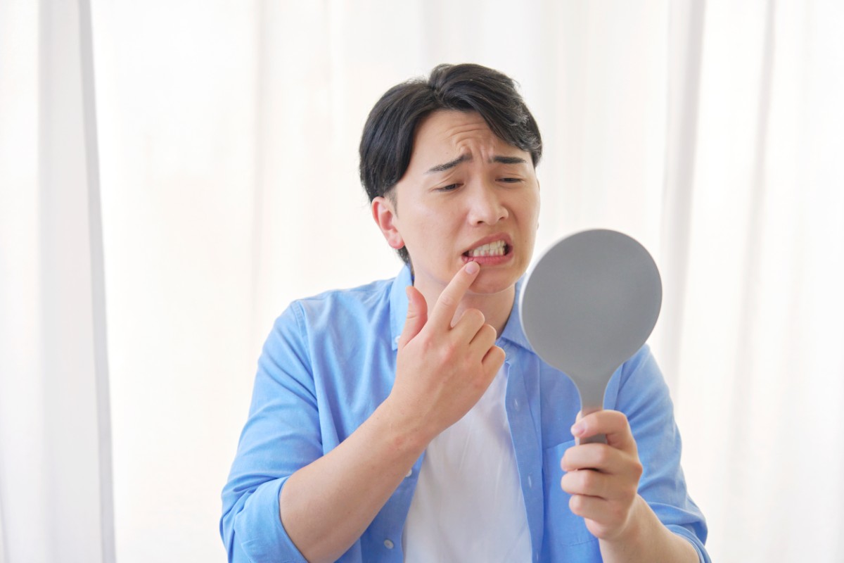 歯周病のセルフチェックをしている男性