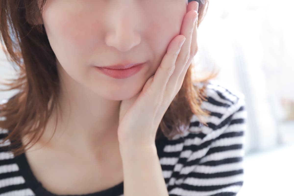 抜歯後に痛みを感じる女性